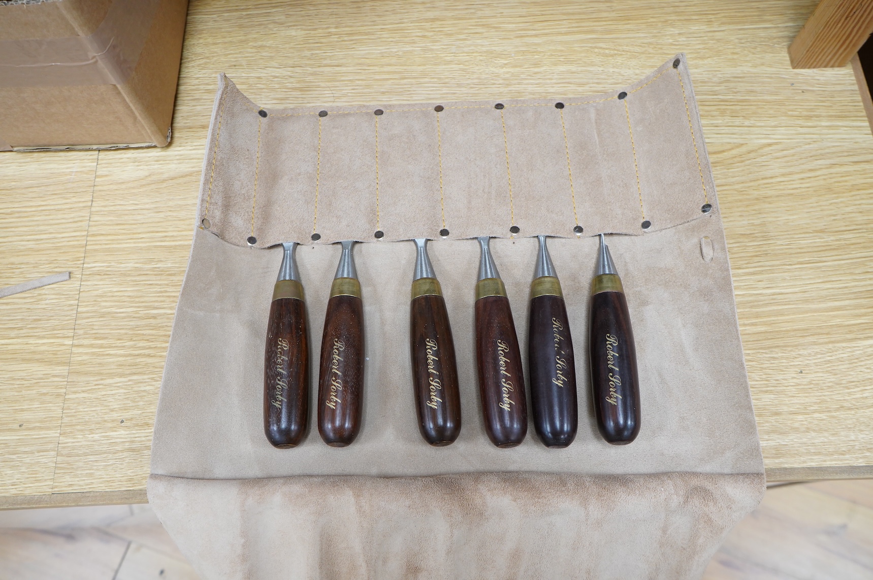 Two sets of Robert Sorby woodworking chisels, both in Kuny’s of Canada leather tool rolls; a nine piece set with octagonal handles, together with a six piece set with rosewood handles